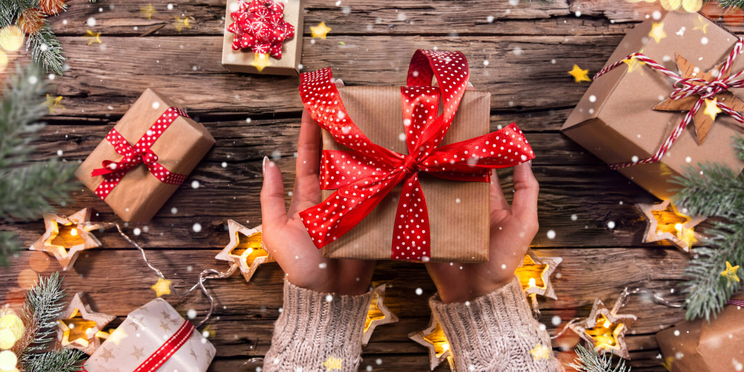 Top view of woman hands with gift box Giving Back to Our Community